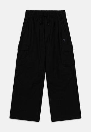 Pantaloni cargo neri con vita elastica, cordino e tasche laterali. Realizzati in un tessuto morbido; presentano un piccolo logo sulla parte anteriore.
