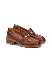 Mocasines de cuero marrón con un diseño de costura, detalles de hardware en tono dorado y una suela texturizada resistente. Tacón bajo apilado para mayor estabilidad.
