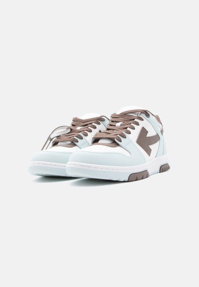 Ζευγάρι λευκά και ανοιχτογάλανα αθλητικά παπούτσια με καφέ κορδόνια και σχεδιασμό βέλους, τοποθετημένα δίπλα-δίπλα σε λευκό φόντο.