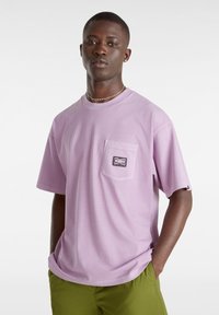 T-shirt a maniche corte di colore lavanda, realizzato in cotone, dotato di una tasca sul petto con etichetta nera e vestibilità comoda.