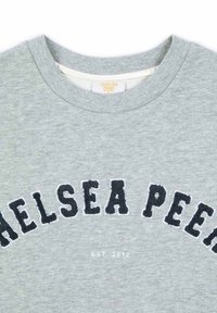 Šedá mikina s vroubkovaným výstřihem, dekorativní text "CHELSEA PEERS" v námořnické modři s texturovaným povrchem a "EST. 2012" v bílé barvě níže.