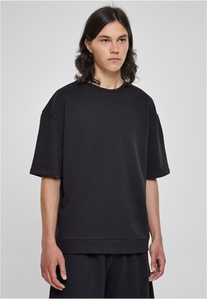 Sort oversized T-shirt lavet af blød bomuldsblanding, med rund halsudskæring og korte ærmer. Simpelt design uden synlige mønstre eller accenter.