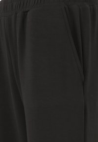 Zwarte joggingbroeken gemaakt van zachte katoenmix stof, met een elastische tailleband, een relaxed fit en zijzakken. Gladde textuur zonder patronen.