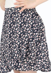 Hosenrock mit floralem Druck in Marineblau, ausgestattet mit weißen und roten Blumen, einem ausgestellten Design und einem rüschendekorierten Saum. Aus leichtem Stoff gefertigt.