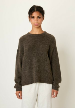 Brown oversized sweater made of soft, fluffy material; features a round neck, long sleeves, and a relaxed fit. Simple and textured design.