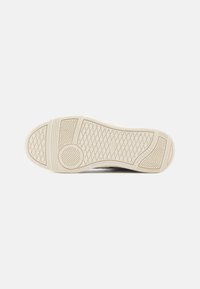 Kummist kinga tald, millel on tekstuuriga chevron-muster. Kreemika värvi tald, millel on ümar konts ja sile serv parema haarde saavutamiseks.