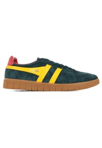 Zapatillas de ante en verde oscuro con rayas amarillas y detalles rojos. Presentan una superficie texturizada y una suela de goma con un diseño segmentado.