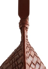 Brown leather bag featuring a woven texture and a thick, wide shoulder strap. Notable detail includes the braided seam where the strap attaches.