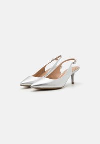 Srebrne slingback sandale s koničastim nosem, metalnim zaključkom in srednje visokim petom. Oblikovanje vključuje diskreten detajl z zaponko.