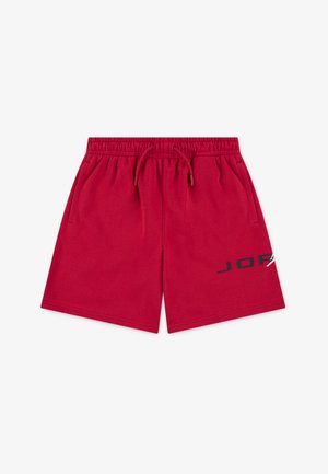 Red athletic shorts made from soft material, featuring an elastic waistband with drawstring, side pockets, and a logo in black on the front.