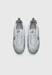 Tenis de malha cinza e branco com um padrão de grelha, colarinho acolchoado e atacadores brancos. Detalhes em cinza escuro e sola em borracha completam o design.