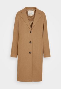 Brun uldblandet frakke med reverskrave, lukning med fire knapper og sidelommer. Afslappet pasform med en glat indvendig foring.