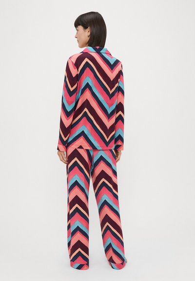 Multifarvet pyjamasæt med et zigzag-mønster i pink, blå og mørkerød. Den langærmede top har krave og løstsiddende bukser.