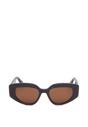 Lunettes de soleil œil de chat noires avec des verres teintés marron et des montures épaisses sur fond blanc.