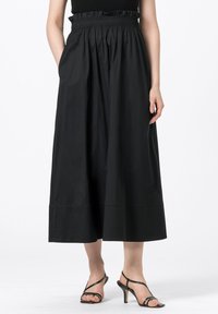 Svart ankel-lång kjol med ett rynkat midjeband, tillverkad av slät tyg, med sidofickor och en rak silhuett.