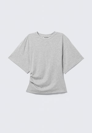Ljust grå kortärmad T-shirt med rund hals och lätt sidofåll, liggande platt på en vit bakgrund.