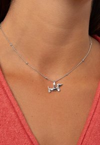 Collana in argento con pendente a forma di bassotto, con una finitura liscia, una catena delicata e piccole perline rotonde integrate nel design.