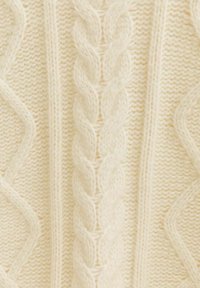Cremefarbener Strickpullover mit einem Kabelmuster, strukturierten Wellen und einer glatten Oberfläche. Das Design betont Wärme und Gemütlichkeit.