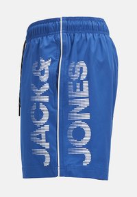 Shorts de bain bleus avec une taille élastique, texte logo blanc sur le côté et un détail de fermeture éclair blanche contrastant. Matériau lisse et léger.