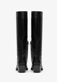 Černé kožené vysoké boty s mírně zaoblenou špičkou, bočními zipy a silným, vrstveným podpatkem. Hladký povrch s minimálními detaily.