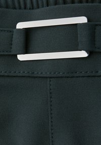 Cinturón de tela verde oscuro con una hebilla rectangular plateada. Presenta costuras visibles y una textura suave y elástica.