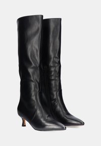 Botas de cuero negro hasta la rodilla con un acabado suave, punteras puntiagudas y un tacón pequeño. Cuentan con una cremallera lateral para ponerlas y quitarlas con facilidad.