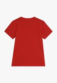 Maglietta rossa a maniche corte in cotone, caratterizzata da un collo rotondo e un design semplice senza grafiche o decorazioni.