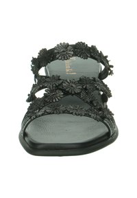 Black sandal featuring flat sole, multiple straps adorned with flower appliqués, and a textured footbed. Open design for breathability.