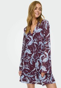 Lillasest lilleline kleit pikkade läbipaistvate varrukatega ja V-kujuline kaelus. Omab siniseid lillemustreid tumedal taustal, pehme ja kerge kangas.