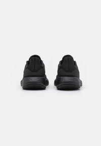Scarpe sportive nere con tomaia in rete testurizzata, suola ammortizzata e collare imbottito. Presentano un design snello e un tacco arrotondato.