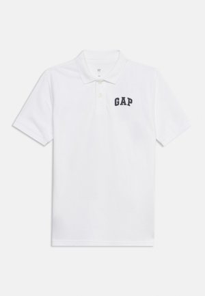 Witte polo met korte mouwen, kraag en twee knopen, met een zwart "GAP" tekstlogo op de linkerborst.