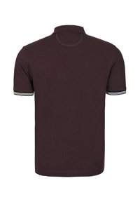 Mörkt vinröd pikétröja med klassisk krage, korta ärmar och randiga detaljer på ärmsluten. Slät textur, avslappnad design.