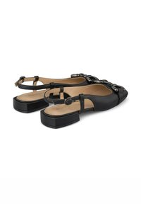 Zapatos slingback de cuero negro con puntera cuadrada, suela plana y un acento decorativo de cadena en la parte delantera. Acabado suave, diseño minimalista.