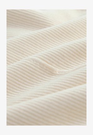 Textured fabric in a light cream color with raised diagonal ribbing. Material appears soft and plush, highlighting depth and subtle sheen.