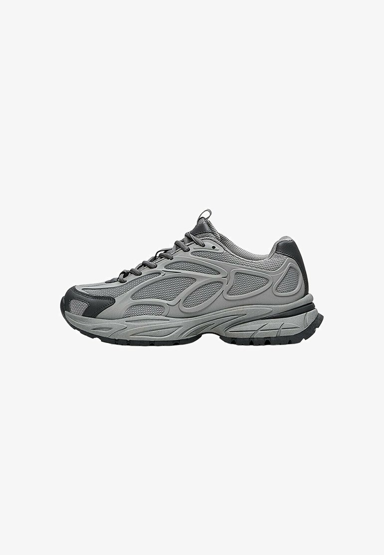Baskets de sport grises et noires avec dessus en mesh et synthétique, semelle épaisse texturée, lacets, et languette de tirette au talon et à la languette, vue de côté.