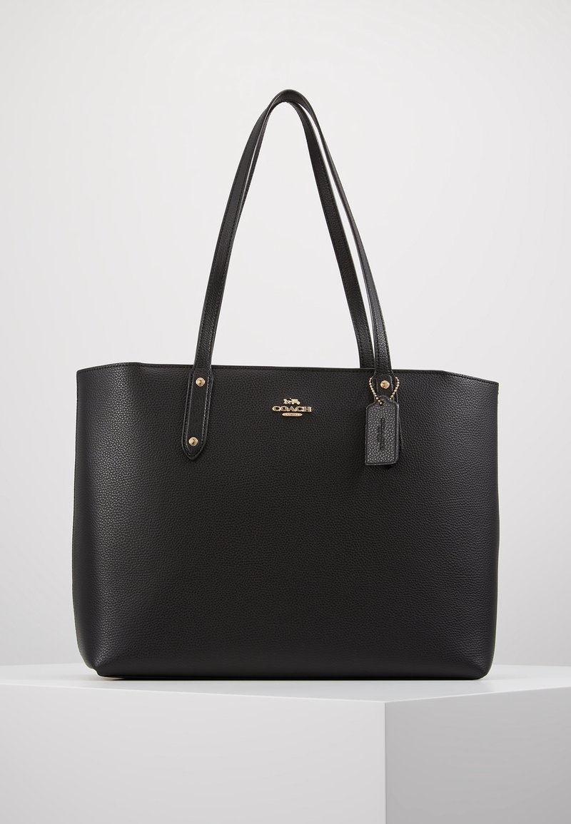 Musta nahkainen olkalaukku, jossa on kuviollinen pinta, kullanväriset metalliosat, kaksinkertaiset kahvat ja pienikokoinen kiinnitetty nimilappu. Yksinkertainen, suorakulmainen muotoilu.