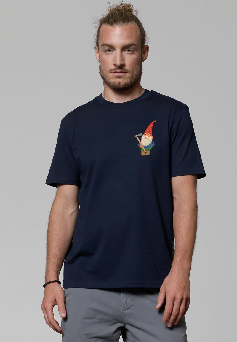 T-shirt en coton bleu marine avec un graphique de gnome sur le côté gauche de la poitrine, col rond, manches courtes et coupe décontractée.