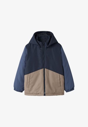 Veste d'hiver à capuche avec fermeture éclair intégrale sur le devant, partie supérieure bleu marine, partie inférieure beige, manches longues avec poignets élastiques et poches latérales.
