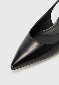 Escarpin noir en cuir avec un bout pointu et un talon ouvert, texture lisse et design minimaliste. Équipé d'une semelle intérieure rembourrée pour plus de confort.
