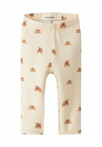 Geribbelde, roomkleurige leggings met een patroon van bruine croissants. Een elastische tailleband en afgewerkte manchetten maken het ontwerp compleet.