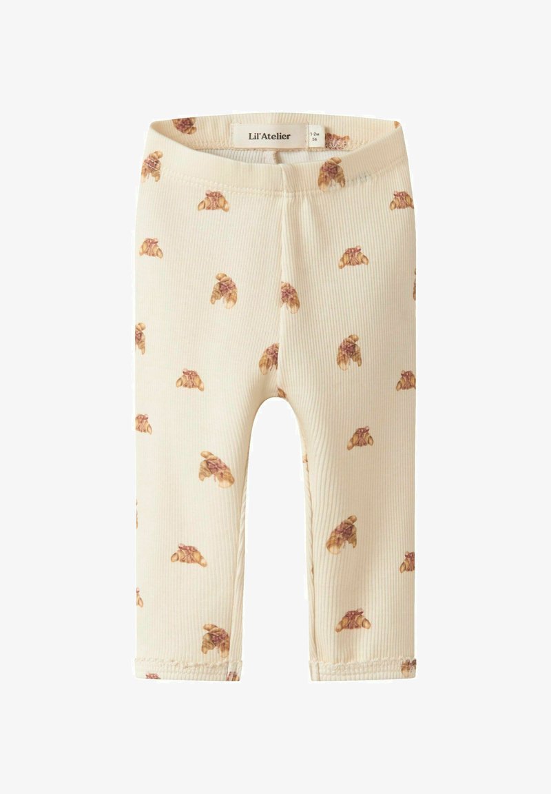 Geribbelde, roomkleurige leggings met een patroon van bruine croissants. Een elastische tailleband en afgewerkte manchetten maken het ontwerp compleet.