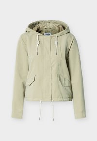Φωτεινό πράσινο, κοντό μπουφάν με κουκούλα, δύο μπροστινές τσέπες, ρυθμιζόμενο κορδόνι και μεταλλικές λεπτομέρειες στα άκρα του κορδονιού.