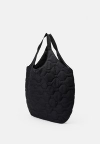Saco tote preto com um padrão hexagonal acolchoado, feito de um tecido macio. Apresenta duas alças robustas e um topo aberto espaçoso.