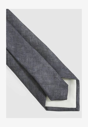 Tumehallist tekstureeritud kangast mida, millel on sile valge vooder ja terav lõpp; kitsas disain, mis sobib ametlikuks kandmiseks.