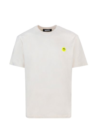T-shirt bianco in cotone con scollatura rotonda, maniche corte e una piccola grafica di una faccina sorridente gialla nella parte sinistra del petto.