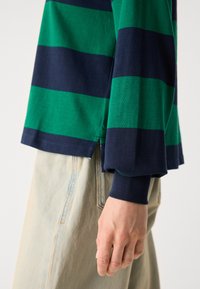 Gestreepte lange mouwen shirt met groene en marineblauwe horizontale strepen, gemaakt van zachte katoen, met een zijsplit en ribgebreide manchetten.