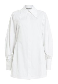Blouse blanche manches longues avec un col large et pointu, boutons dissimulés à l'avant et poignets légèrement froncés aux manches.