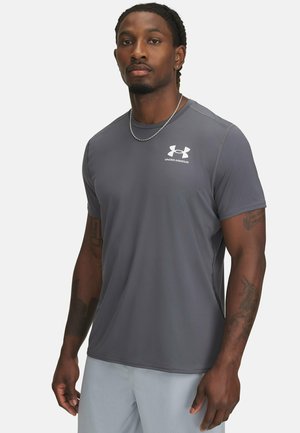 Siva atletska majica s kratkimi rokavi, izdelana iz lahkega materiala. Na prsih ima belo logo Under Armour. Gladka tekstura.