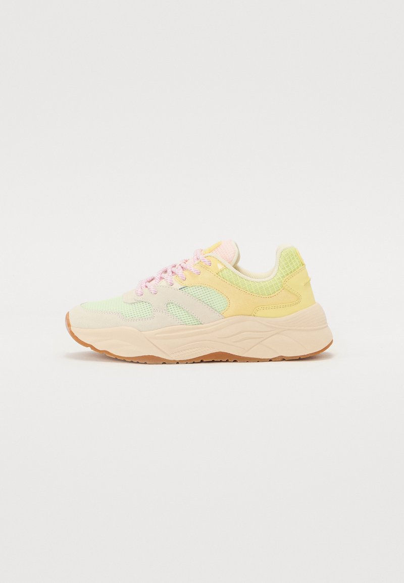 Sneaker multicolore con un mix di pannelli in rete morbida gialla, verde e rosa chiaro, dotata di una suola spessa beige e lacci rosa.
