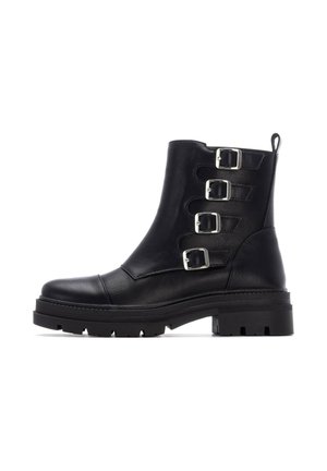 Botas de tobillo de cuero negro con tres correas de hebilla plateada, punta redondeada, suela gruesa y un acabado texturizado.